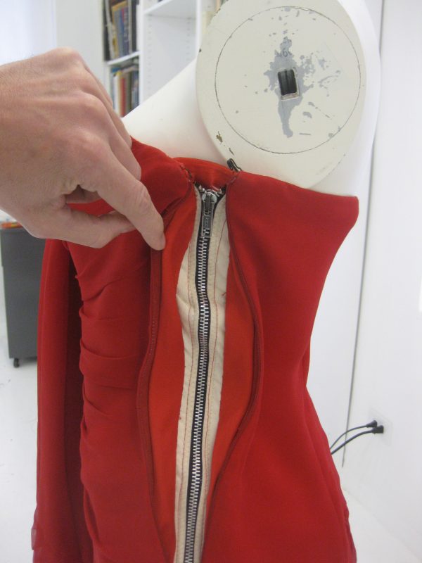 With invisible dress zipper entirely down. Even if the failure of the invisible zipper is catastrophic, the dress will stay up and your delicate modesty will be maintained. There is a light slipstitch anchoring the lining of the dress to the face of the drill corset to keep things tidy.